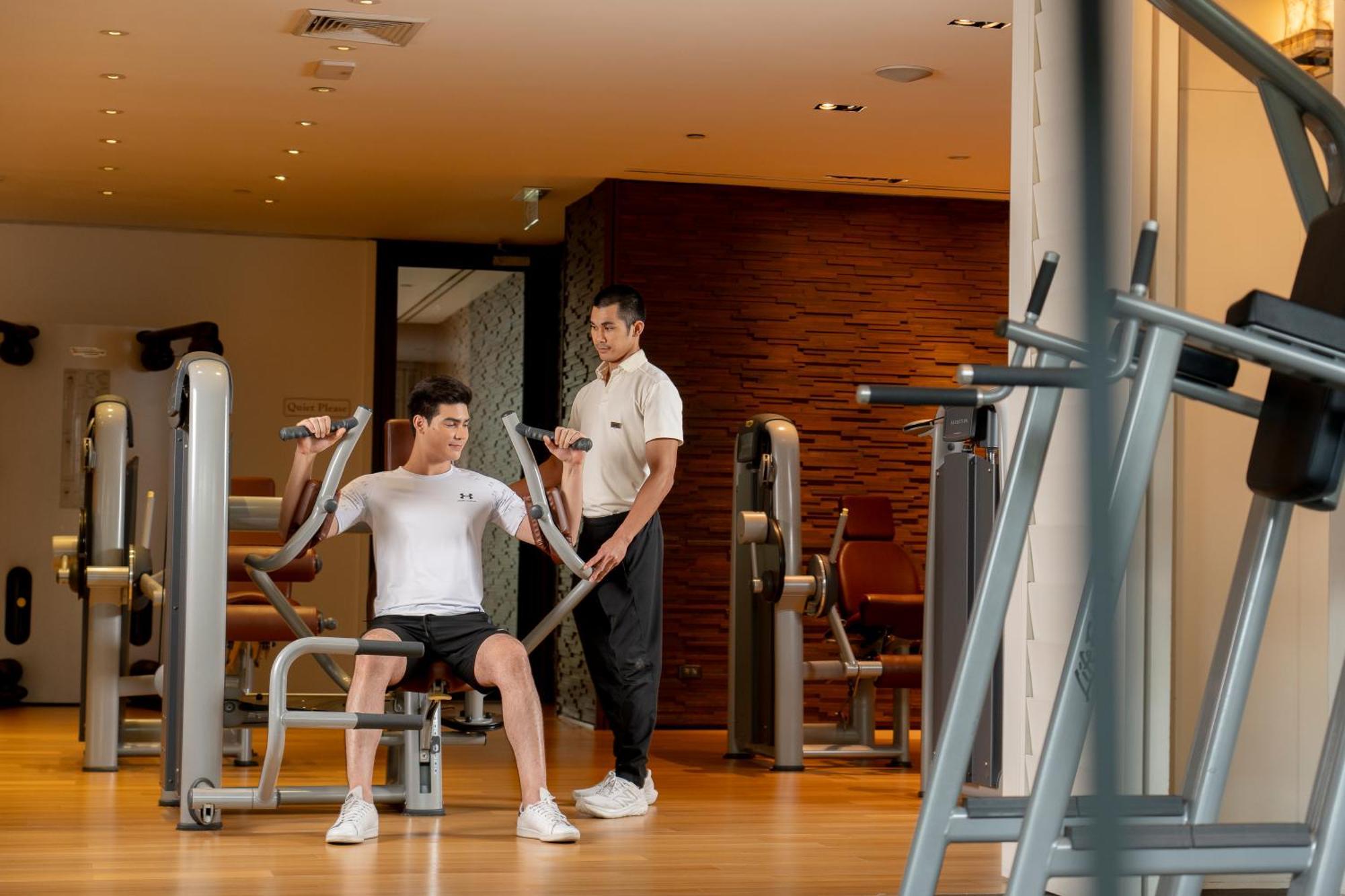 Grand Hyatt Erawan Bangkok Hotel Kültér fotó Personal trainer assisting a guest at the gym